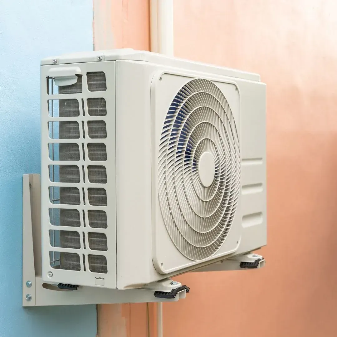 Outdoor ductless mini-split compressor mounted on a wall bracket